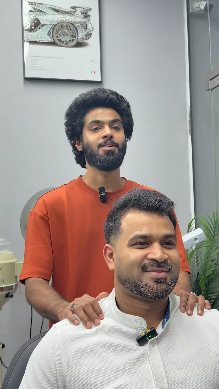 A smiling customer and his barber after a fresh haircut and beard trim