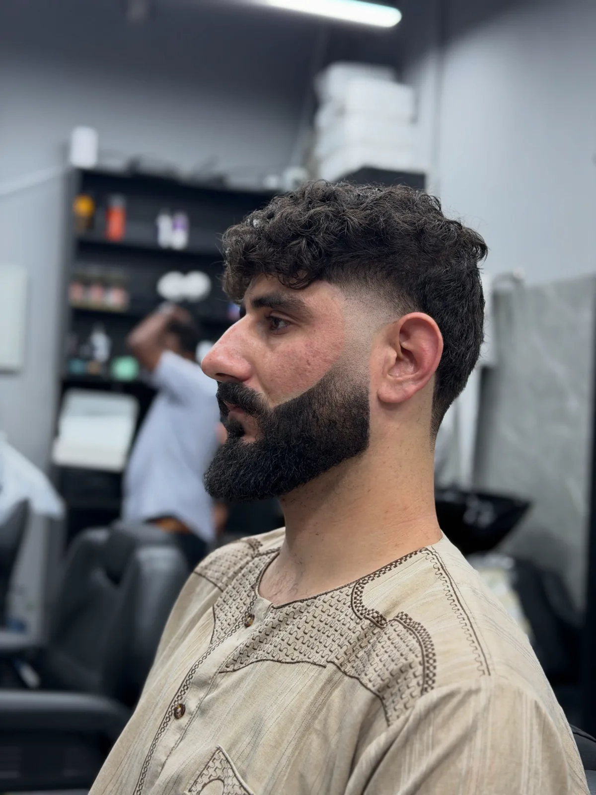 Textured curls with a clean fade and sculpted beard